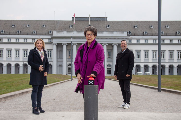 Die Vorsitzdene drückt symbolisch den Start-Knopf vor dem Koblenzer Schloss.